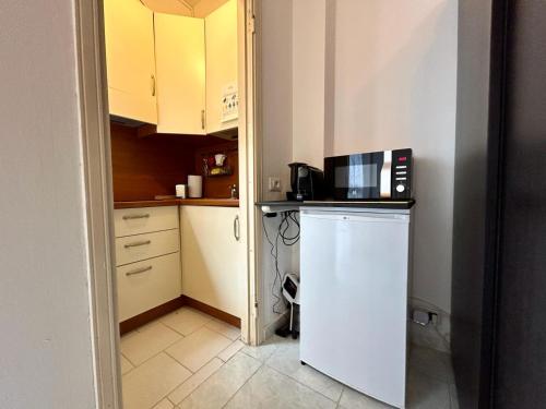 una pequeña cocina con nevera y microondas en Kibilù - Via Quattro Novembre en Corsico