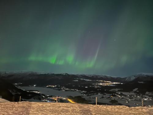 an image of the aurora in the sky over a city at Apartment with beautiful panoramic view in Skulestadmo