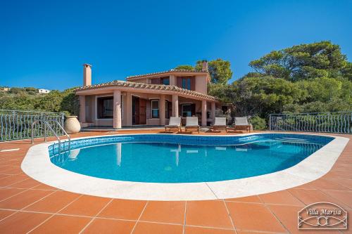 a swimming pool in front of a house at Villa Marisa in Torre delle Stelle