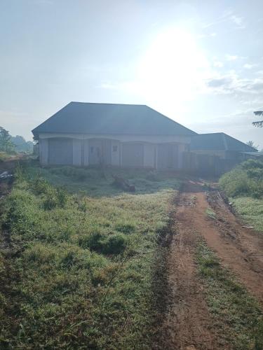 ein Haus auf einem Feld mit einer Schotterstraße davor in der Unterkunft foxxies guest house in Buloba