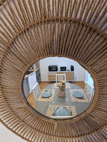 une salle à manger avec une table et un miroir dans l'établissement Cosy et moderne avec Clim - Lac Léman, à Thonon-les-Bains