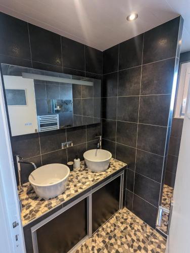 une salle de bain avec deux lavabos sur un comptoir dans l'établissement Cosy et moderne avec Clim - Lac Léman, à Thonon-les-Bains