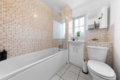 a bathroom with a toilet and a tub and a sink at Spacious 2 bedroom flat by Zen Abodes Short Lets & Serviced Accommodation with Free Parking & Free Wifi in Watford