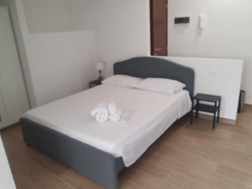 Schlafzimmer mit einem Bett mit weißer Bettwäsche und Kissen in der Unterkunft GIANGY HOME in Casteldaccia