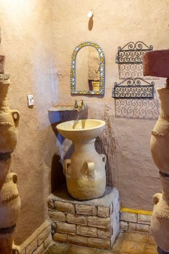 a bathroom with a stone sink and a mirror at kasbah luna del sur in Erfoud