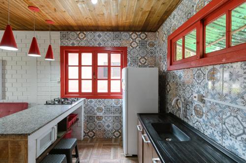 a kitchen with a white refrigerator and a window at Hotel Praia Do Rosa in Praia do Rosa
