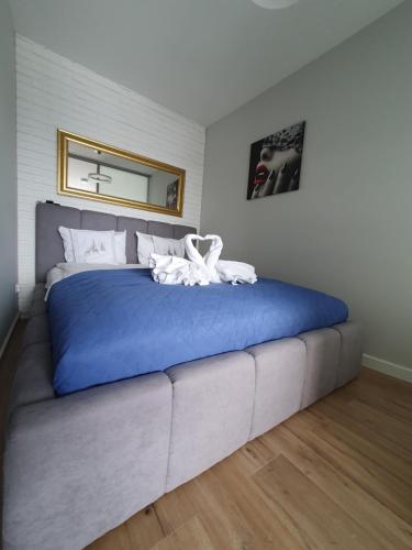 Un dormitorio con una gran cama azul con espejo en Apartament Widokowy Wisła, en Wisła