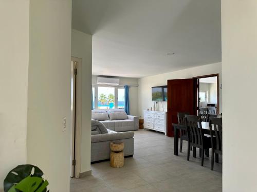 a living room with a couch and a dining room at MERAKII SEAVIEW ESCAPE CURACAO in Willemstad