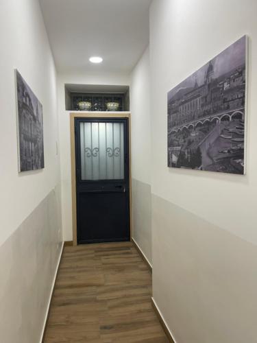 een hal met een zwarte deur en twee foto's aan de muur bij Calabrò 21 Appartament in Catania