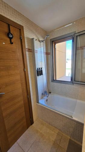 a bathroom with a bath tub and a window at El Castillo Golf Salinas-wifi in La Guirra