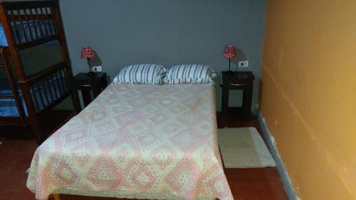 a bedroom with a bed with two night stands and two lamps at Como en casa in Uspallata