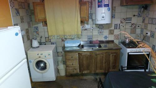 a small kitchen with a sink and a washing machine at Como en casa in Uspallata