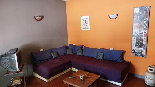 a living room with a purple couch and a table at Como en casa in Uspallata
