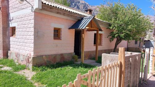 a small house with a fence in front of it at Como en casa in Uspallata