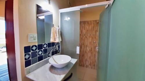 ein Badezimmer mit Waschbecken und Dusche in der Unterkunft Solar dos Ventos in Alto Paraíso de Goiás