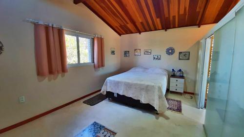 ein Schlafzimmer mit einem Bett und einem Fenster in der Unterkunft Solar dos Ventos in Alto Paraíso de Goiás