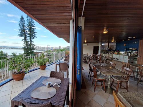 a restaurant with tables and chairs on a balcony at HOTEL DAIFA in Florianópolis