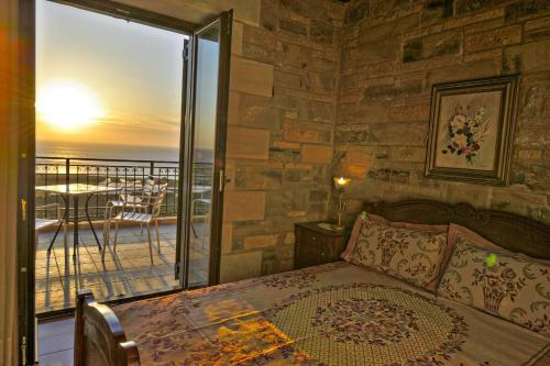 a bedroom with a bed with a view of the ocean at Fotini Traditional Villas in Kavoúsion
