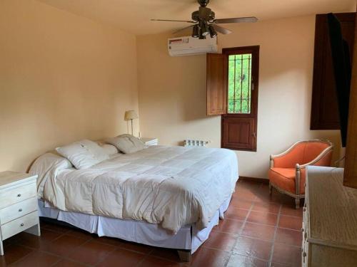 1 dormitorio con 1 cama y ventilador de techo en Casa con piscina y gran parque en Los Cardales en Los Cardales