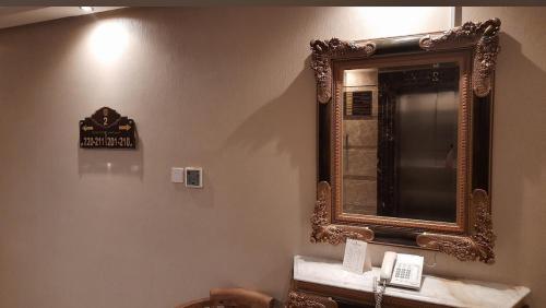 ジッダにあるGrand Park by VERTAの洗面台付きのバスルームの壁に鏡