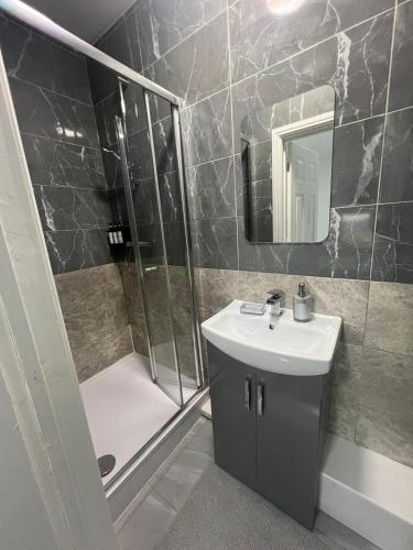a bathroom with a shower and a sink and a mirror at Luxury in luxury out in Nottingham