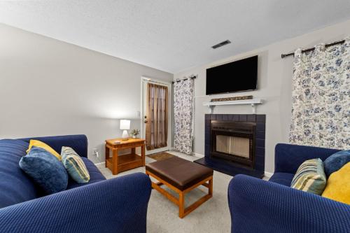 a living room with a blue couch and a fireplace at Comfortable Greensboro Condo in Greensboro
