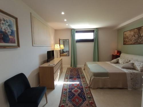 una camera con letto, sedia e televisore di Verde Mare Isola a Carrozziere