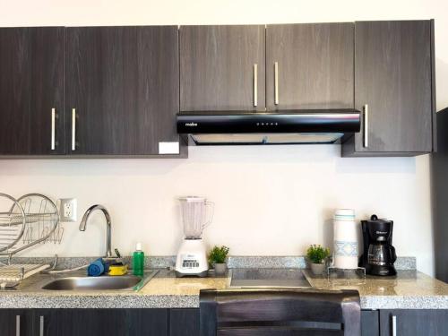 una cucina con mobili in legno e un piano di lavoro di Dpto. moderno zona boulevard a Morelia