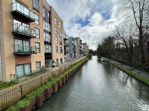 赫默爾亨普斯特德的住宿－Luxury Canal-side Apartment, Hemel Hempstead, Free parking, Perfect for Contractors，一条河,在建筑物旁边有船