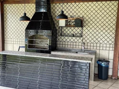 een keuken met een bakstenen oven en een wastafel bij Angra dos Sonhos in Angra dos Reis