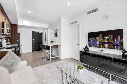 a living room with a couch and a tv on a wall at Prime Location 1-Bed Retreat With Free Parking in Miami