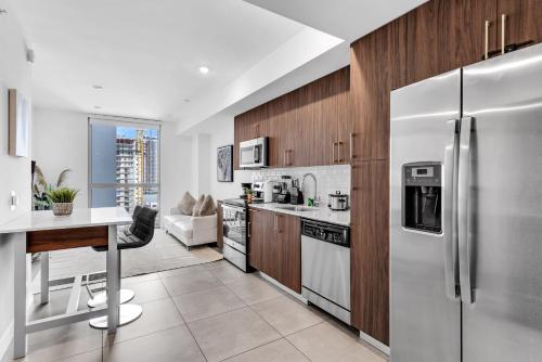 a kitchen with stainless steel appliances and wooden cabinets at Prime Location 1-Bed Retreat With Free Parking in Miami