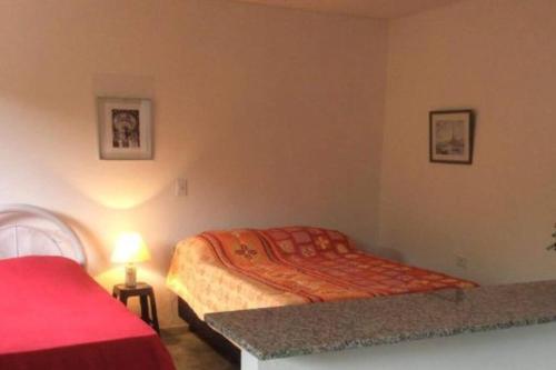 Dormitorio pequeño con 2 camas y lámpara en Chalé Mirante do Vale en Piatã