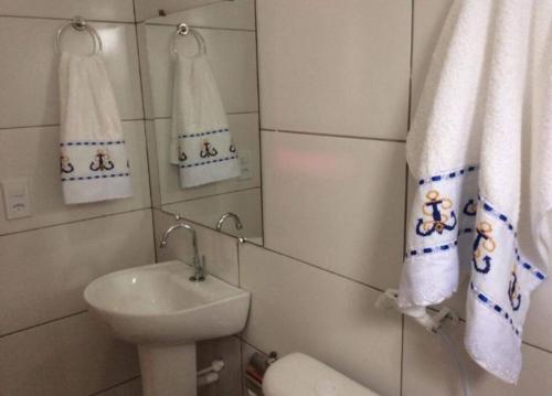 y baño con lavabo, aseo y toallas. en Chalé Mirante do Vale en Piatã