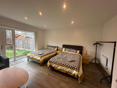 a room with two beds and a table and a window at C U Property Ltd in Manchester