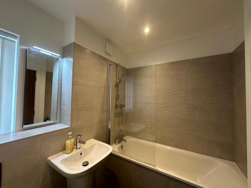 a bathroom with a sink and a bath tub at C U Property Ltd in Manchester