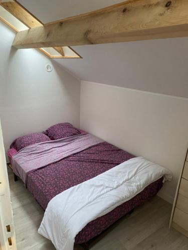 - une chambre avec un lit doté de draps et d'oreillers violets dans l'établissement maison de prescillia et frederic, à Boisset