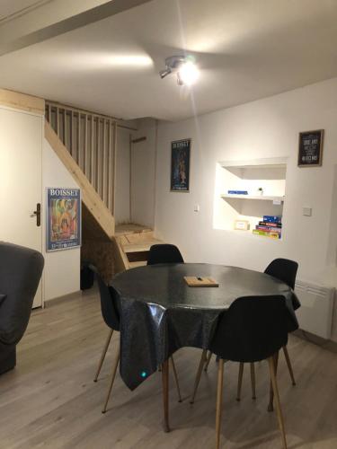 une salle à manger avec une table, des chaises et un escalier dans l'établissement maison de prescillia et frederic, à Boisset