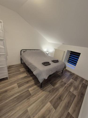 une chambre avec un lit et un parquet dans l'établissement Se relaxer dans la vallée, à Hombourg-Haut