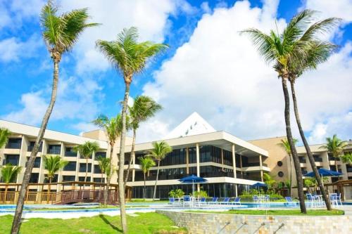 un complexe avec des palmiers en face de lui dans l'établissement Pirâmide palace resort, à Natal