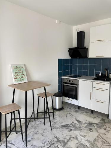 une cuisine avec une table, des chaises et une cuisinière dans l'établissement Studio 50 m de la mer - Centre - Proche mer, à Nice