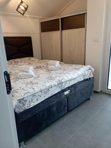 een slaapkamer met een groot bed met een houten hoofdeinde bij Vila Leona B-3 in Divčibare
