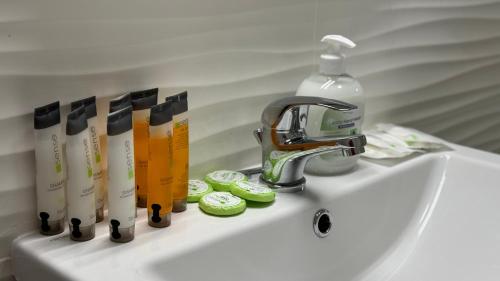 a sink with a faucet and toothbrushes and a bottle of soap at Busteni Mountain View Suites by the River - EV Plug in Buşteni