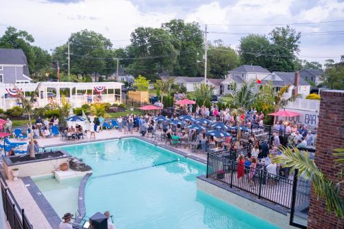 a crowd of people sitting around a pool at a resort at The Shore Club in Spring Lake Heights