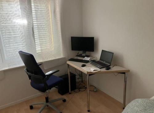a desk with a laptop and a computer on it at Cheap flat close to Baden, CH in Niederrohrdorf
