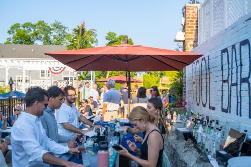 a group of people sitting at tables under an umbrella at The Shore Club in Spring Lake Heights