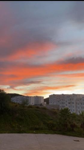 uitzicht op een zonsondergang met gebouwen op de achtergrond bij La Colina in M'diq