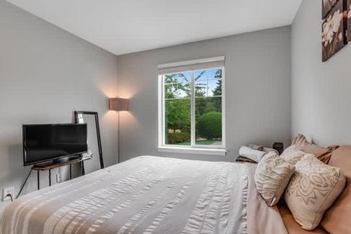 a white bedroom with a bed and a window at Pet Friendly and Spacious Valley View Family Home in Snohomish