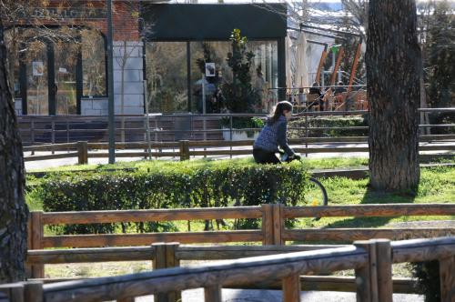 une femme à vélo dans un parc dans l'établissement SUKI HOUSE Chalet 1, à Madrid