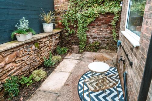 a patio with a table and a chair in front of a building at Rose Cottage in Brough